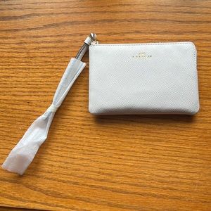 NWT. Coach small clutch with strap. White. Still has packaging and wrapping.
